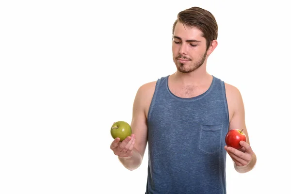 Joven guapo caucásico hombre sosteniendo verde y rojo manzana listo f — Foto de Stock