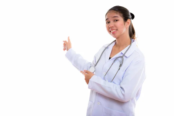 Estúdio tiro de jovem feliz asiático mulher médico sorrindo enquanto mostra — Fotografia de Stock