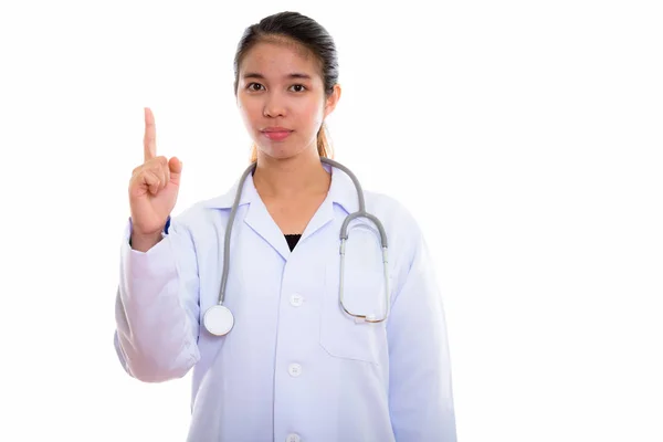 Studio shot van jonge Aziatische vrouw arts wijzende vinger omhoog — Stockfoto