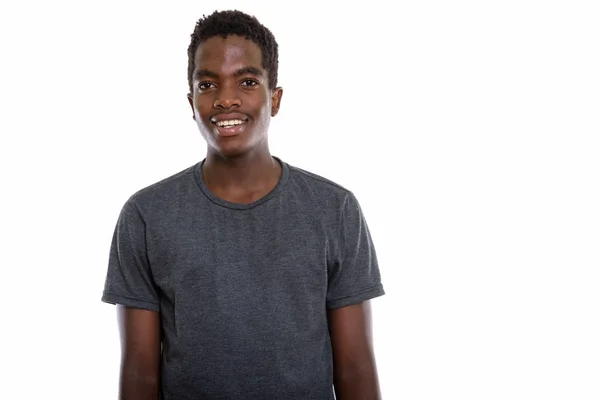 Studioaufnahme eines jungen glücklichen schwarzafrikanischen Teenagers, der lächelnd hin und her lächelt — Stockfoto