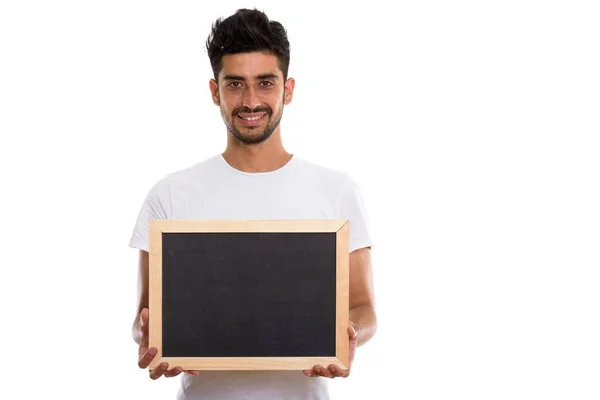 Studio colpo di giovane felice uomo persiano sorridente mentre tiene bla — Foto Stock