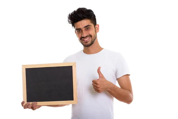 Studio colpo di giovane felice uomo persiano sorridente mentre tiene bla — Foto Stock