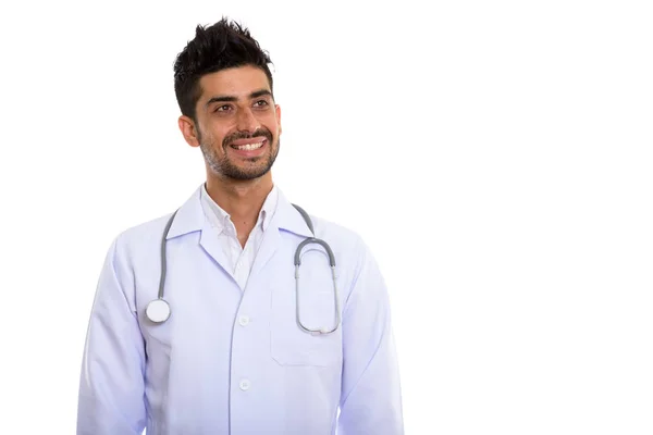 Studio shot of young happy Persian man doctor smiling and thinki — Stock Photo, Image