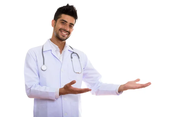 Studio shot of young happy Persian man doctor smiling while show — Stock Photo, Image