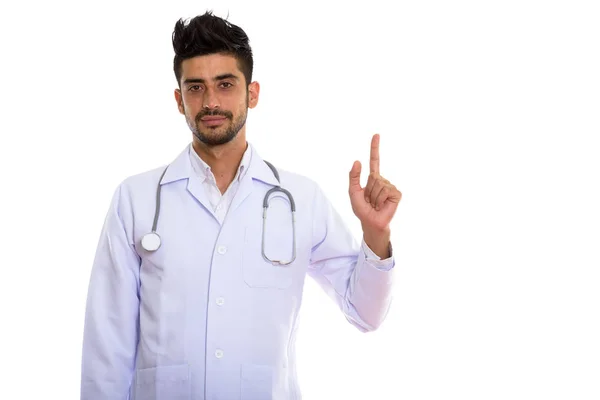 Studio shot of young Persian man doctor pointing finger up — Stock Photo, Image