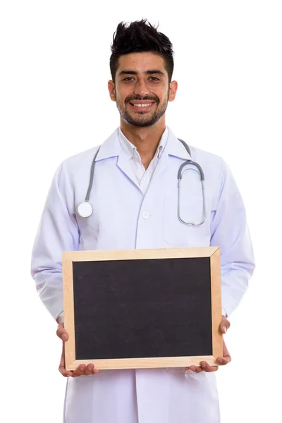 Studio shot of young happy Persian man doctor smiling while hold — Stock Photo, Image