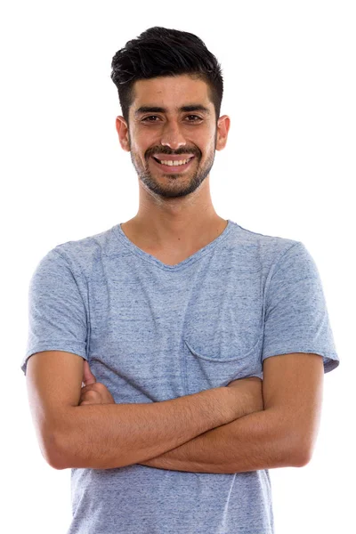 Studio shot de jeune homme persan heureux souriant avec les bras croisés — Photo