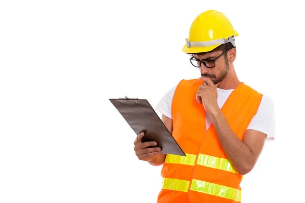 Studio shot of young Persian man construction worker thinking wh — Stock Photo, Image