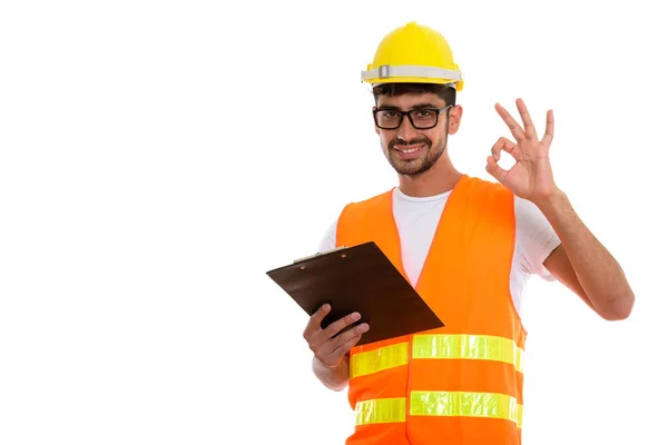 Studio shot of young happy Persian man construction worker smili — Stock Photo, Image