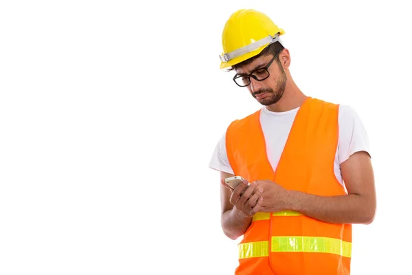 Studioaufnahme eines jungen persischen Bauarbeiters mit Handy — Stockfoto