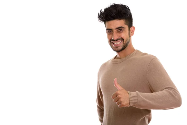 Estudio disparo de joven feliz persa hombre sonriendo mientras da thum — Foto de Stock