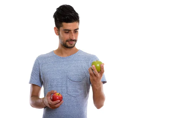 Estudio de un joven persa sosteniendo una manzana roja y mirando un — Foto de Stock