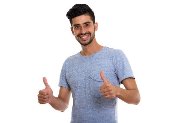 Estudio disparo de joven feliz persa hombre sonriendo mientras da thum — Foto de Stock