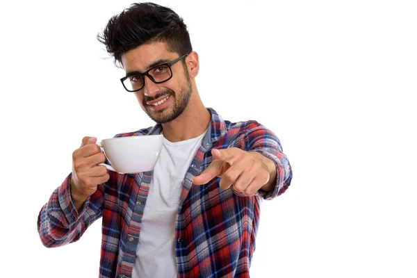 Studio shot of young happy Persian man smiling while holding cof — Stock Photo, Image