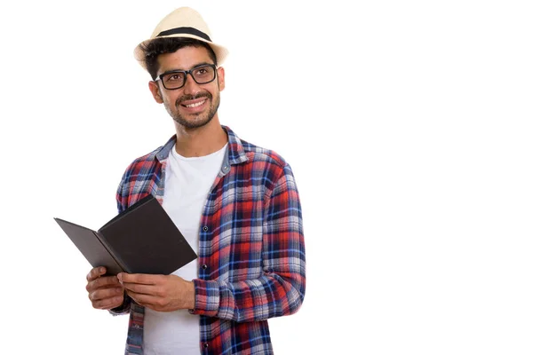 Studio shot of young happy Persian man smiling while holding boo — Stock Photo, Image