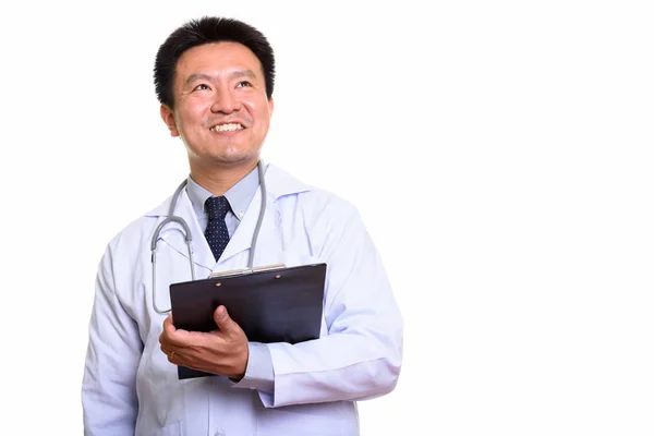 Feliz japonês homem médico sorrindo enquanto segurando prancheta e th — Fotografia de Stock