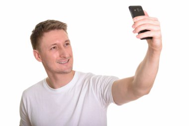 Mutlu yakışıklı beyaz adam cep telefonuyla selfie çekiyor. 