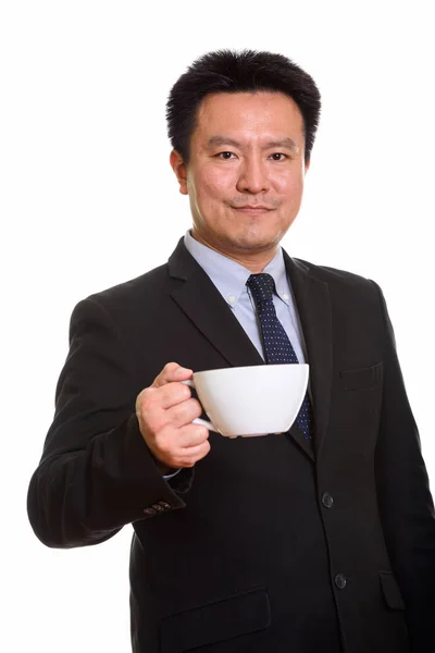Studio shot van Japanse zakenman holding koffiekopje — Stockfoto