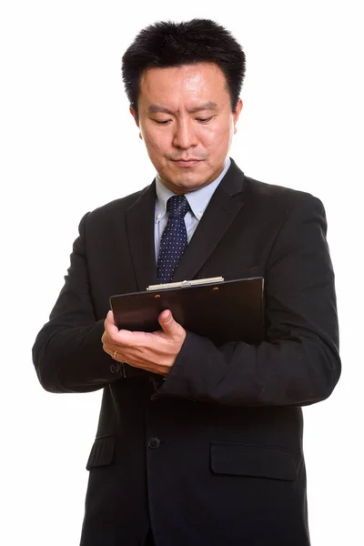 Estudio de un empresario japonés leyendo en el portapapeles — Foto de Stock