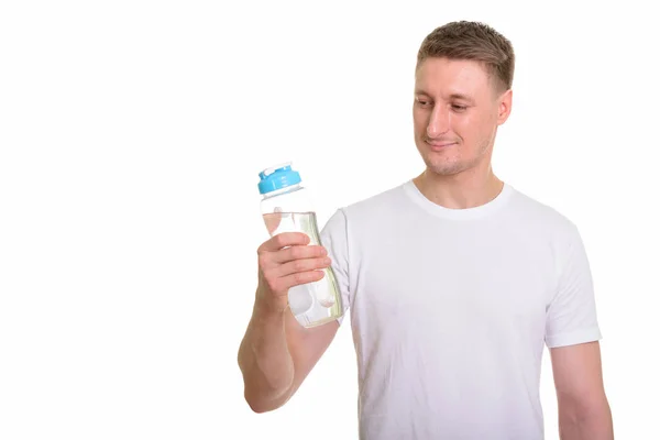 Schöner kaukasischer Mann hält Wasserflasche für Fitnessstudio bereit — Stockfoto