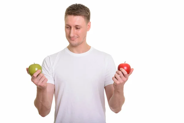 Hombre caucásico guapo sosteniendo manzana verde y roja listo para el gimnasio — Foto de Stock