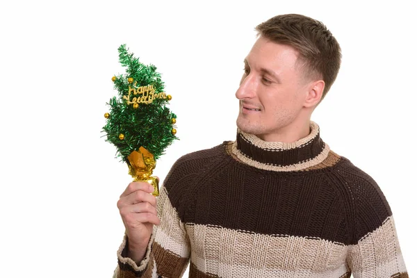Bonito homem caucasiano segurando árvore Feliz Ano Novo — Fotografia de Stock