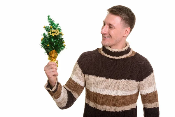 Hombre caucásico guapo feliz sosteniendo árbol de Año Nuevo feliz — Foto de Stock