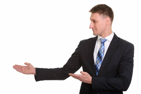 Profile view of handsome Caucasian businessman showing something — Stock Photo, Image