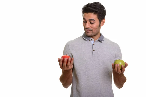 Joven hombre persa guapo elegir entre manzana roja y verde — Foto de Stock