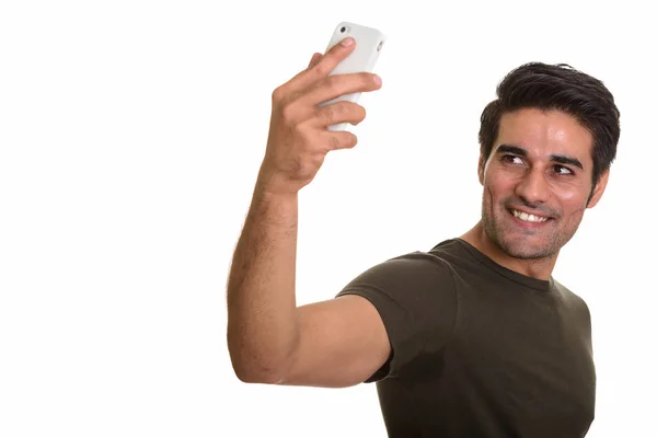 Young happy Persian man taking selfie with mobile phone — Stock Photo, Image