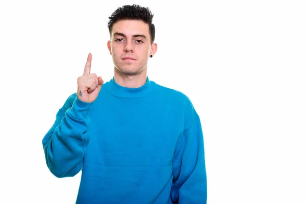 Studioaufnahme eines jungen Mannes, der mit erhobenem Zeigefinger zeigt — Stockfoto