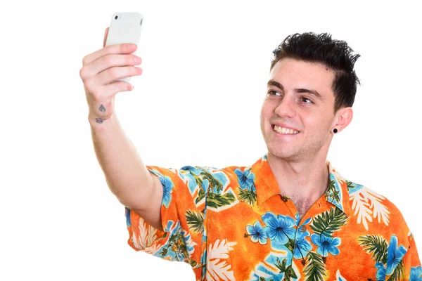 Estúdio tiro de jovem feliz sorrindo ao tomar selfie pictu — Fotografia de Stock