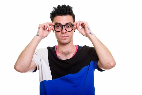 Студийный снимок молодого человека, держащего очки обеими руками — стоковое фото