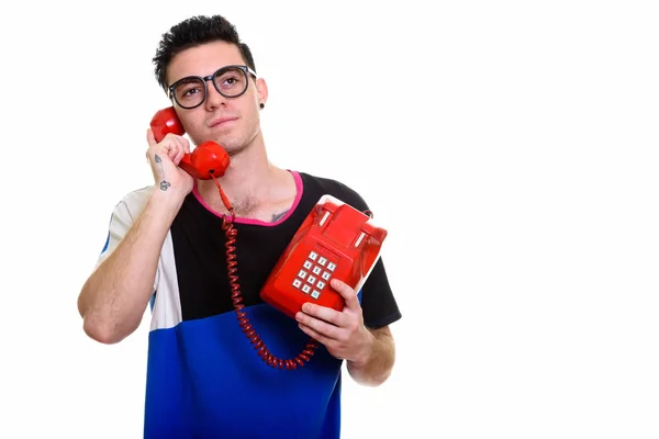 Studio foto di giovane uomo che parla sul vecchio telefono mentre pensa — Foto Stock