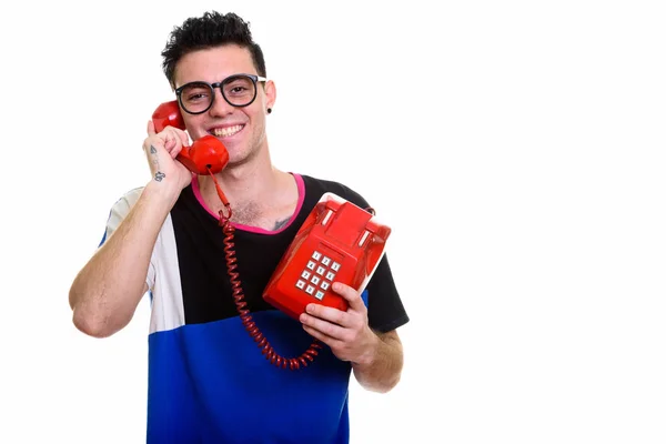 Estúdio tiro de jovem feliz sorrindo enquanto fala na velha tele — Fotografia de Stock