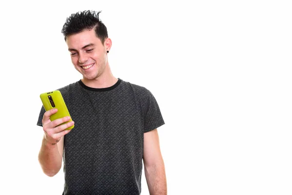 Estúdio tiro de jovem feliz sorrindo ao usar o telefone móvel — Fotografia de Stock