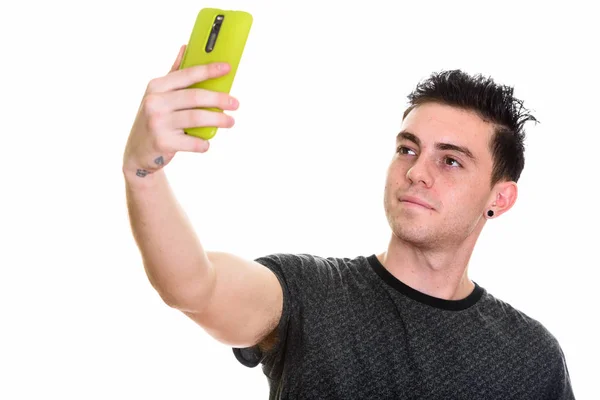 Estúdio tiro de jovem tirando foto selfie com telefone celular — Fotografia de Stock