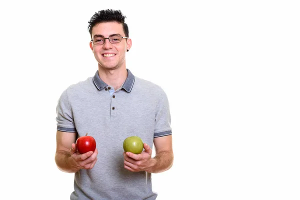 Studio shot of happy young man smiling while holding red and gre — Stock Photo, Image