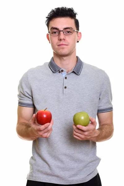 Estudio de un joven sosteniendo manzana roja y verde — Foto de Stock