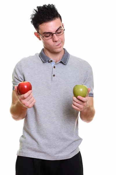 Estudio de tiro de hombre joven elegir entre manzana roja y verde — Foto de Stock