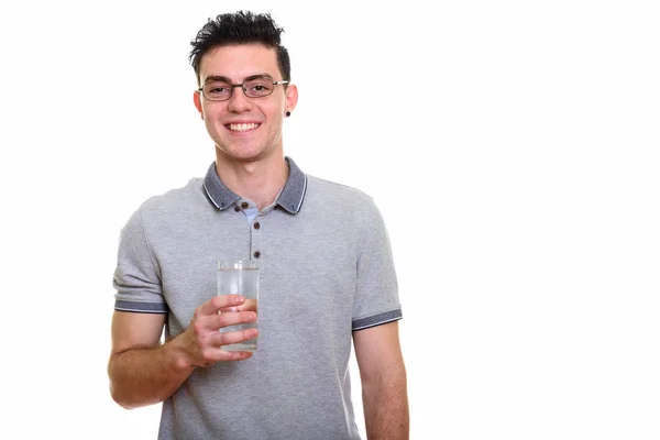 Estudio de tiro de joven feliz sonriendo mientras sostiene el vaso de wa — Foto de Stock