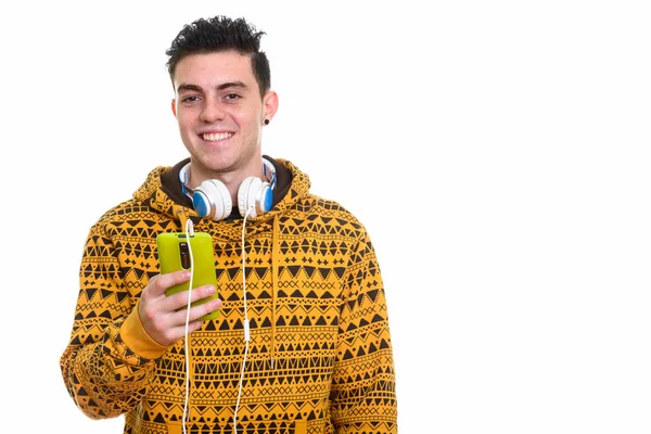 Jovem feliz sorrindo e segurando telefone celular enquanto vestindo h — Fotografia de Stock