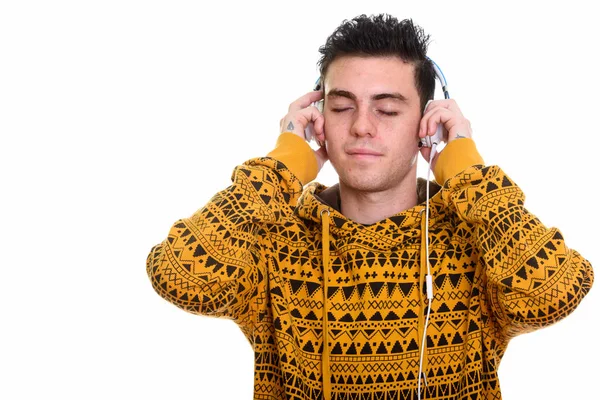 Студійний знімок молодого чоловіка, який слухає музику з закритими очима — стокове фото