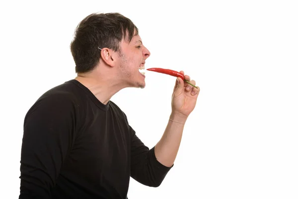 Vy av galna kaukasiska mannen äter röd paprika — Stockfoto