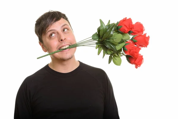 Studio záběr crazy kavkazských muž kousání červené růže a myšlení — Stock fotografie