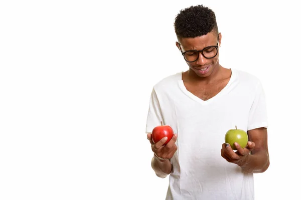 Young happy African man choosing between red and  green apple — Stock Photo, Image