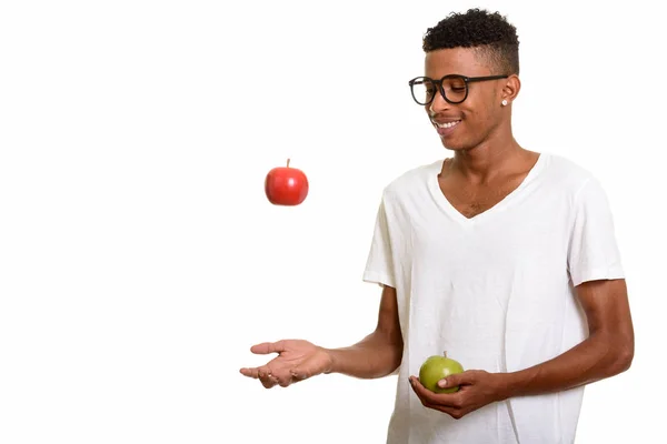 Young happy African man holding red and  green apple — Stock Photo, Image