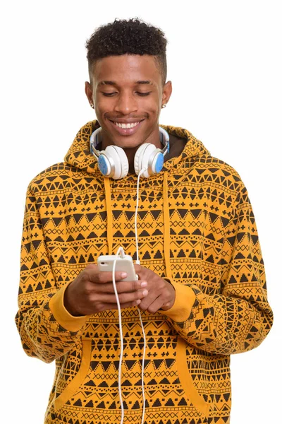 Joven hombre africano feliz usando el teléfono móvil mientras usa headpho —  Fotos de Stock