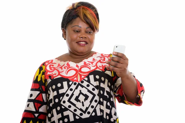 Estudio disparo de la grasa feliz mujer africana negra sonriendo mientras se utiliza — Foto de Stock