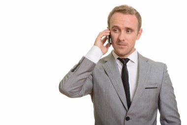Yakışıklı beyaz iş adamı cep telefonuyla konuşuyor.